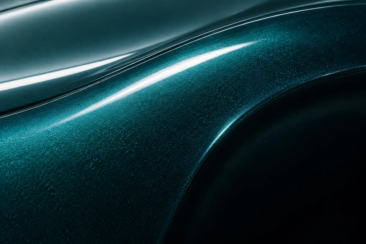 Illustrative close-up of metallic teal paint and studio light